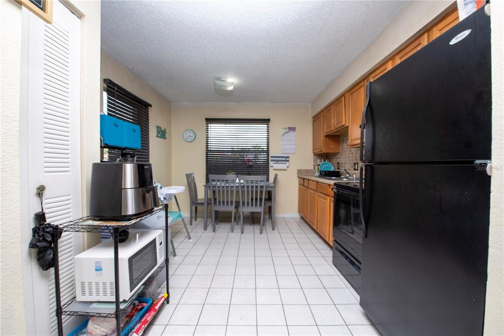 725 Michigan Court, Unit 3 St. Cloud, FL 34769 - Photo 3 of 12 a kitchen with granite countertop a refrigerator stove and microwave