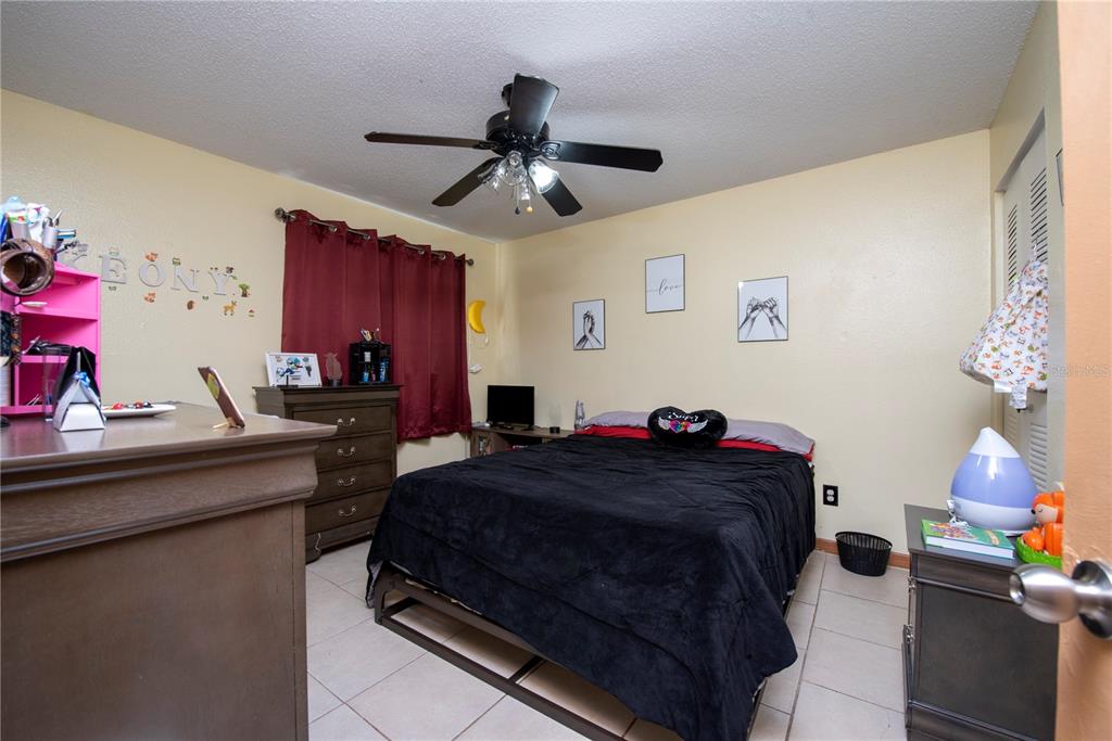 725 Michigan Court, Unit 3 St. Cloud, FL 34769 - Photo 5 of 12 a bedroom with a bed and a chandelier
