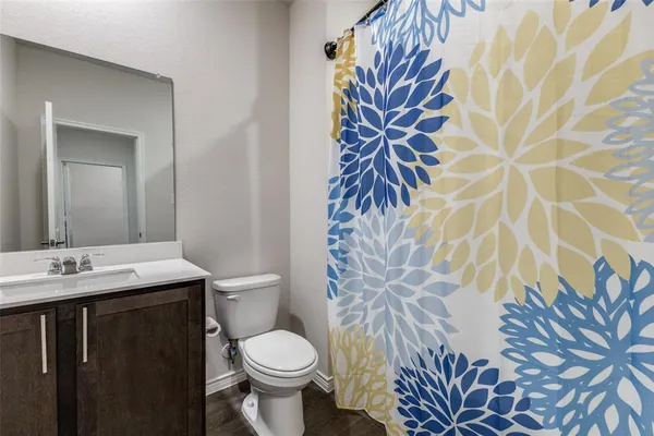 a bathroom with a granite countertop sink and a toilet