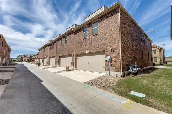 a view of a house with backyard and parking