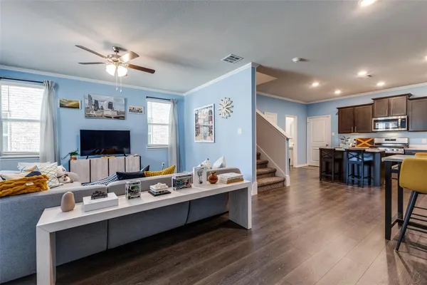a living room with furniture flat screen tv and kitchen view