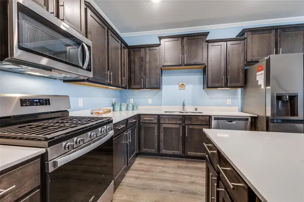 a kitchen with stainless steel appliances a stove a sink and cabinets