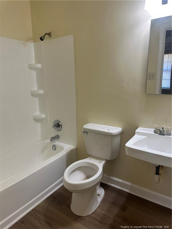 1224 East Manchester Road Spring Lake, NC 28390 - Photo 6 of 12 a white toilet sitting next to a bathroom sink and a bathtub