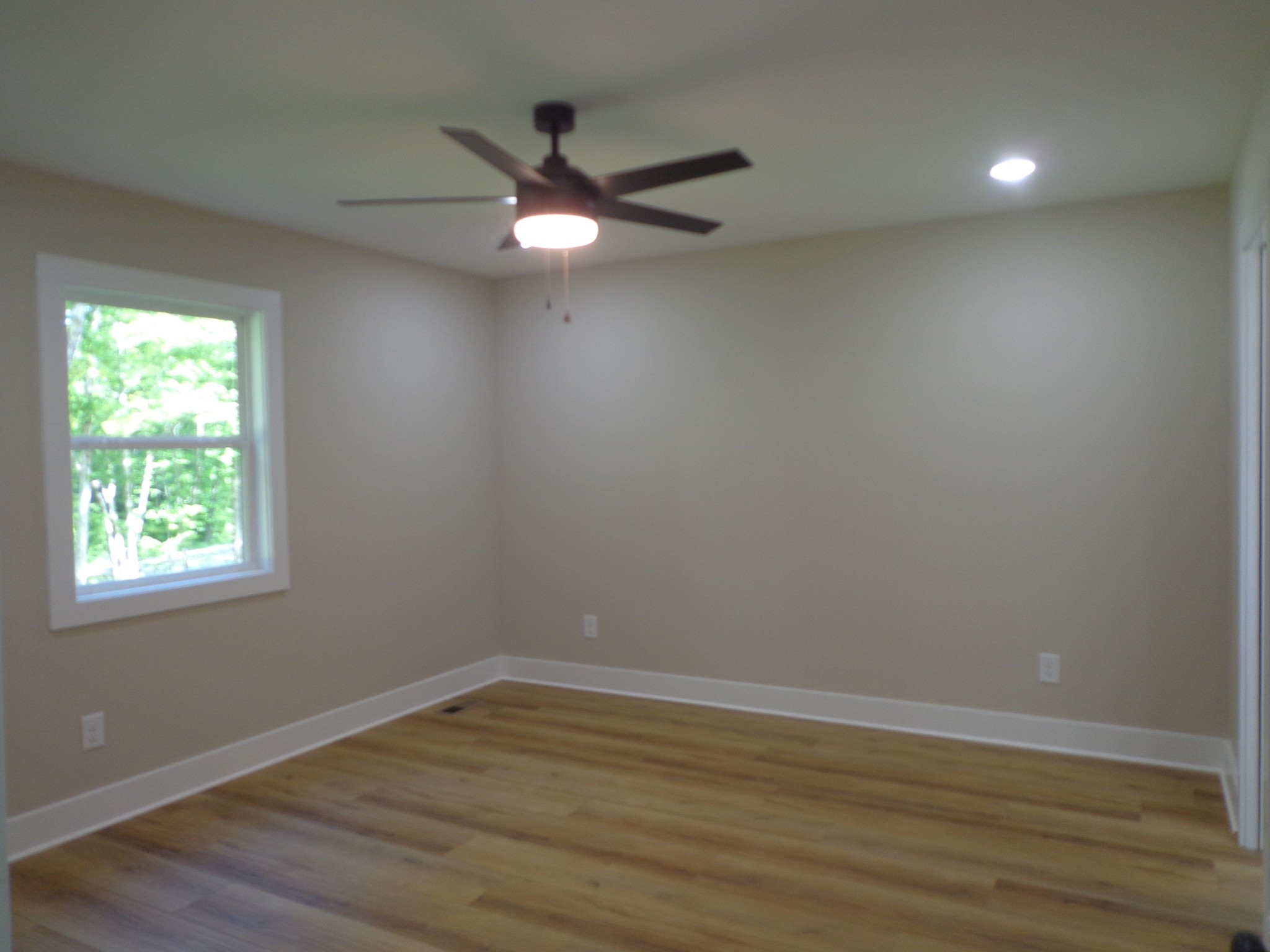 700 Hillcrest Road Waverly, TN 37185 - Photo 25 of 49 an empty room with wooden floor fan and windows