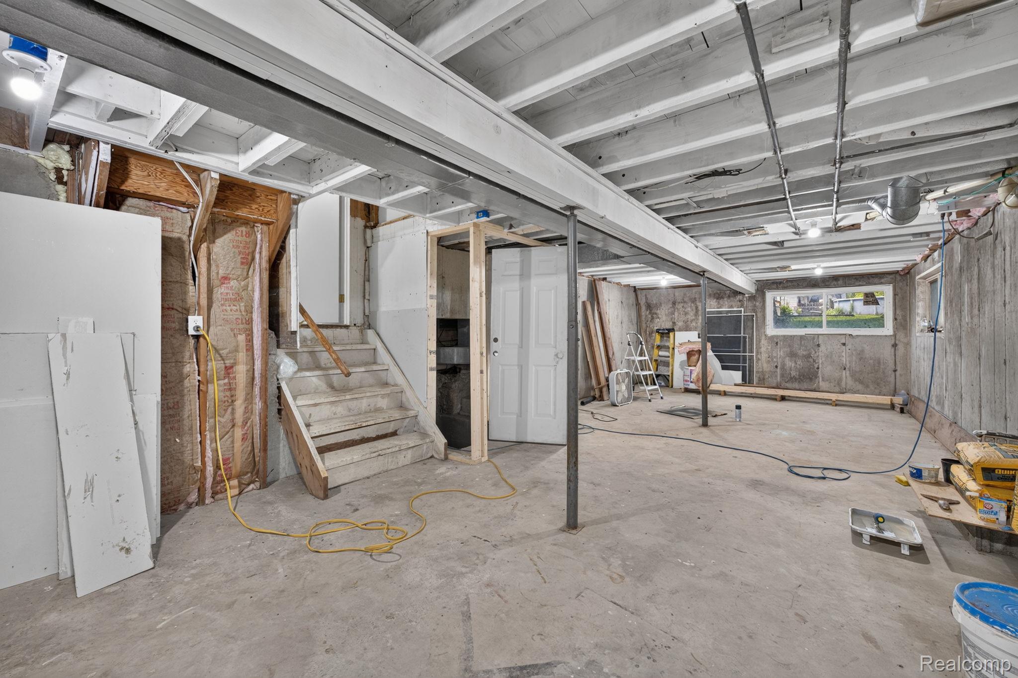 9288 Hilda Lane Flushing, MI 48433 - Photo 37 of 50 Spacious unfinished basement offering concrete flooring, concrete walls, exposed ceiling joists, and a partial wooden staircase