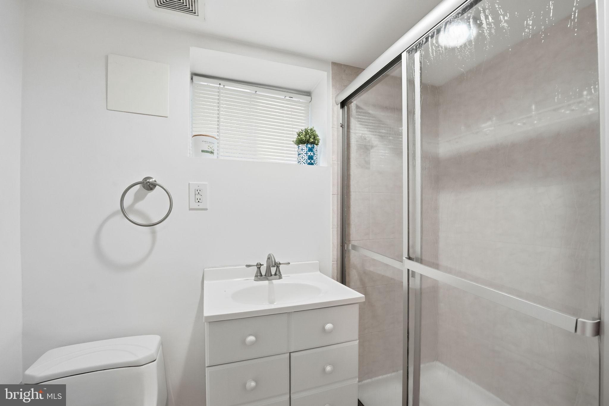 5364 Pooks Hill Road Bethesda, MD 20814 - Photo 21 of 25 a bathroom with a shower sink vanity and toilet