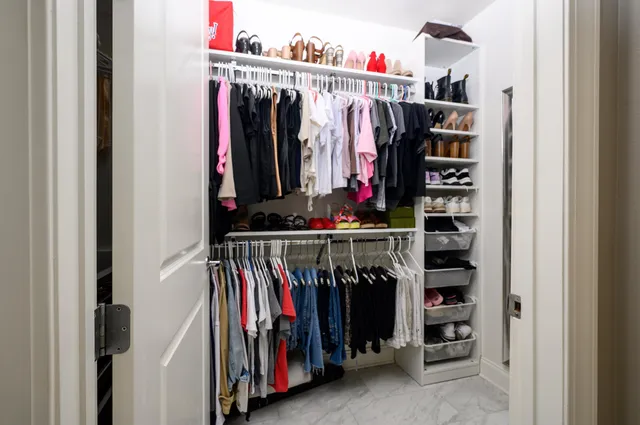 a view of walk in closet with clothes
