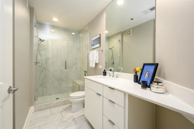 a bathroom with a sink a toilet and shower