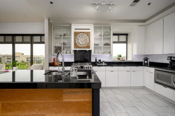 a large kitchen with kitchen island granite countertop a large window and a counter space