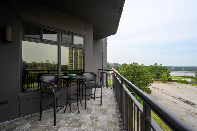 a view of a balcony with chairs and wooden floor