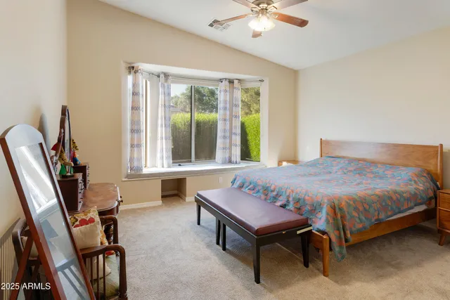 a spacious bedroom with a bed and a large window