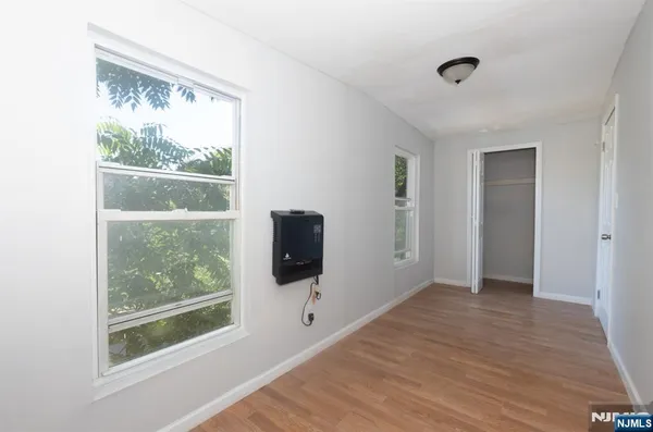 a view of a big room with wooden floor and a window