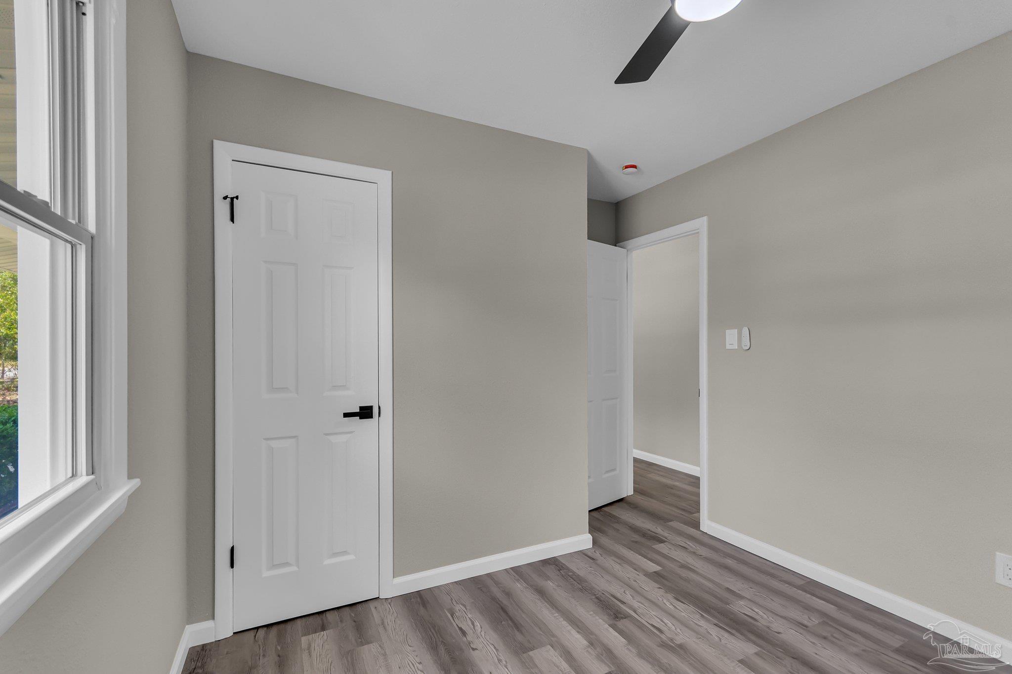 5636 Avondale Road Pensacola, FL 32526 - Photo 12 of 22 a view of an empty room with wooden floor and a window