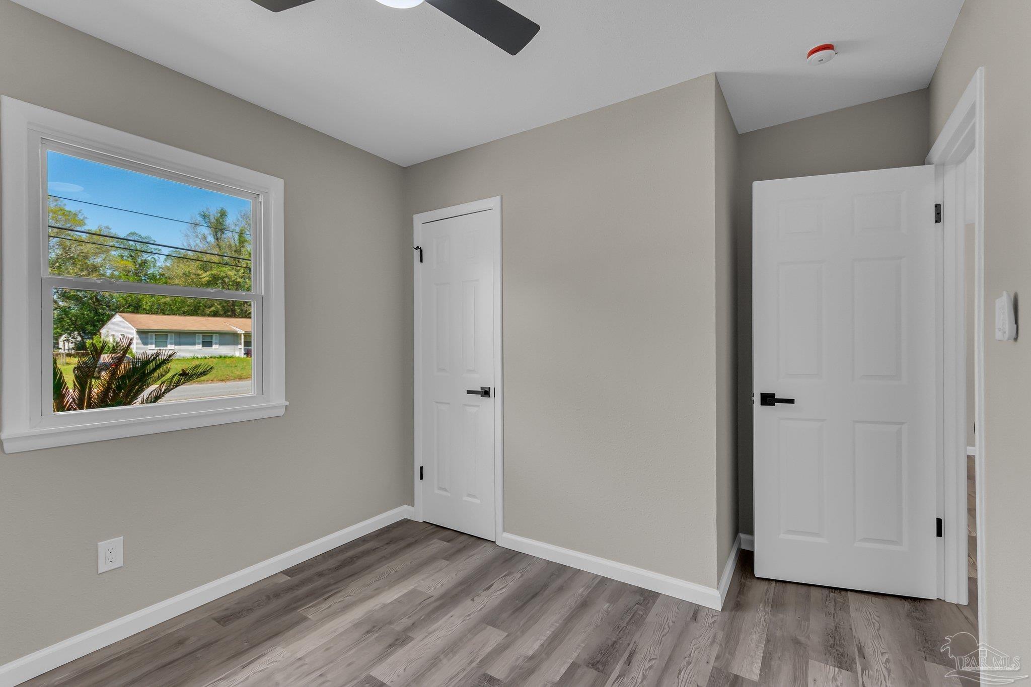 5636 Avondale Road Pensacola, FL 32526 - Photo 13 of 22 a view of an empty room with wooden floor and a window