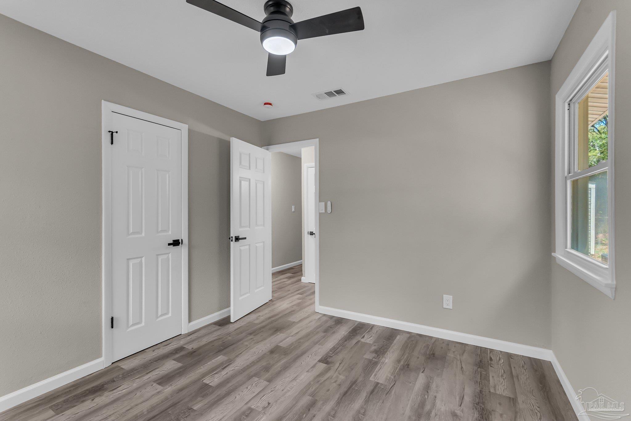 5636 Avondale Road Pensacola, FL 32526 - Photo 17 of 22 wooden floor in an empty room with a window
