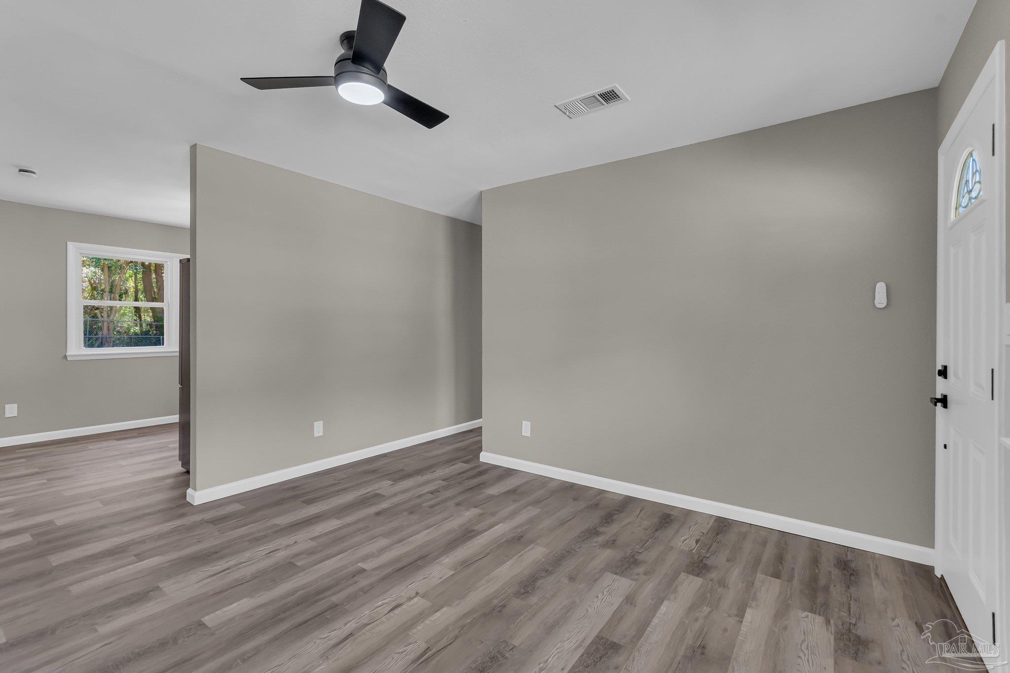 5636 Avondale Road Pensacola, FL 32526 - Photo 3 of 22 an empty room with wooden floor cabinet and windows