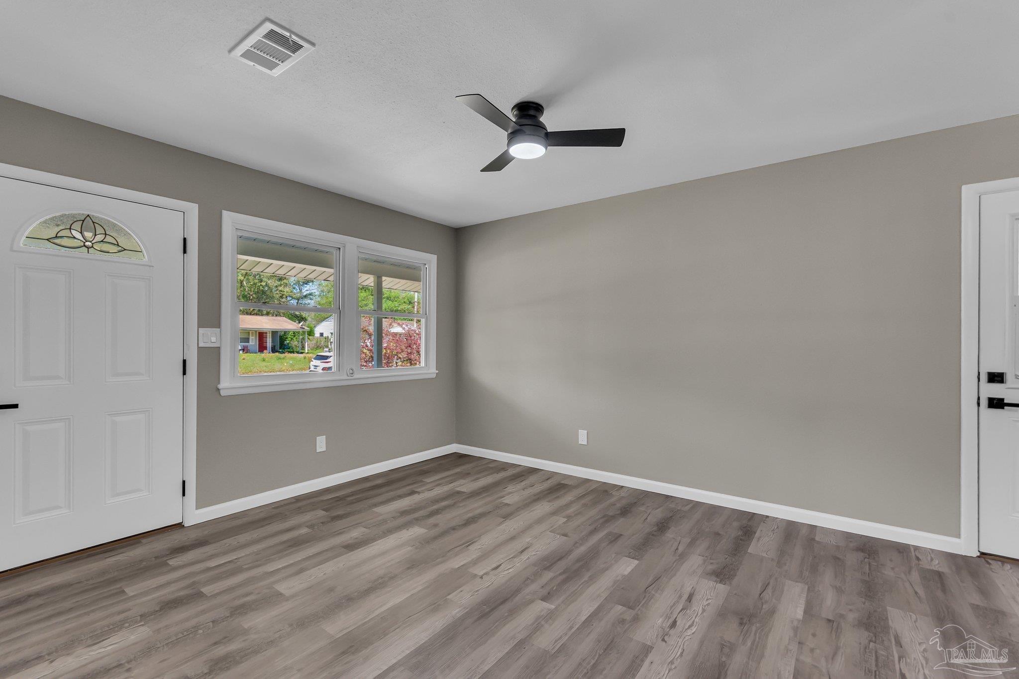 5636 Avondale Road Pensacola, FL 32526 - Photo 6 of 22 an empty room with wooden floor and windows