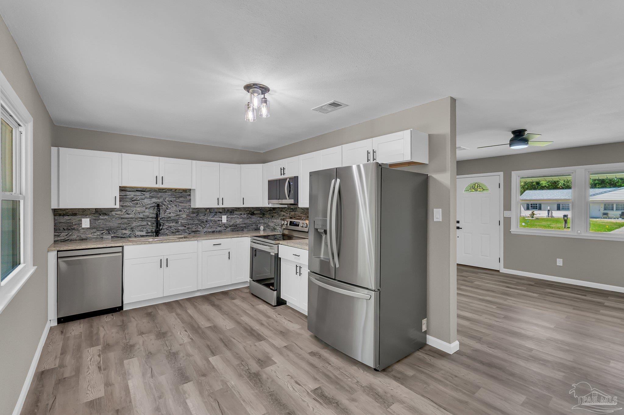 5636 Avondale Road Pensacola, FL 32526 - Photo 8 of 22 a kitchen with a refrigerator and a stove top oven