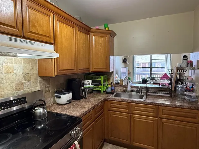 a kitchen with sink a stove and cabinets