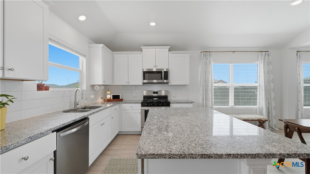1949 Redstart New Braunfels, TX 78130 - Photo 12 of 32 a kitchen with granite countertop a sink a counter top space appliances and cabinets