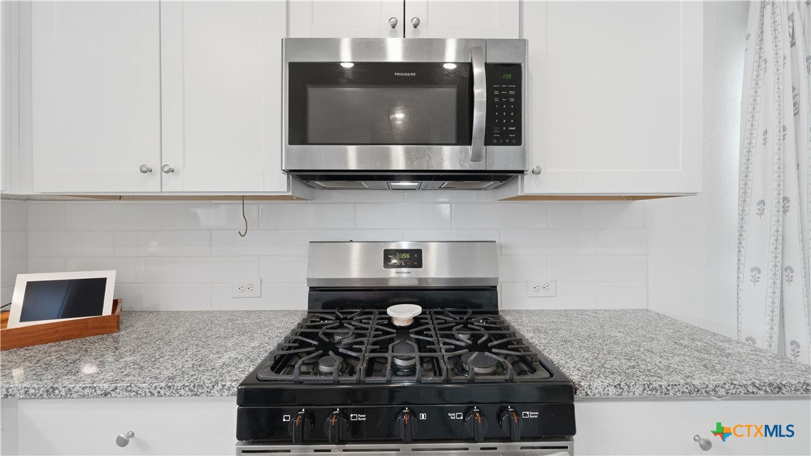 1949 Redstart New Braunfels, TX 78130 - Photo 14 of 32 a kitchen with granite countertop a stove and a sink