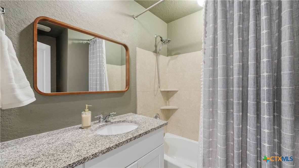 1949 Redstart New Braunfels, TX 78130 - Photo 19 of 32 a bathroom with a granite countertop sink and a mirror