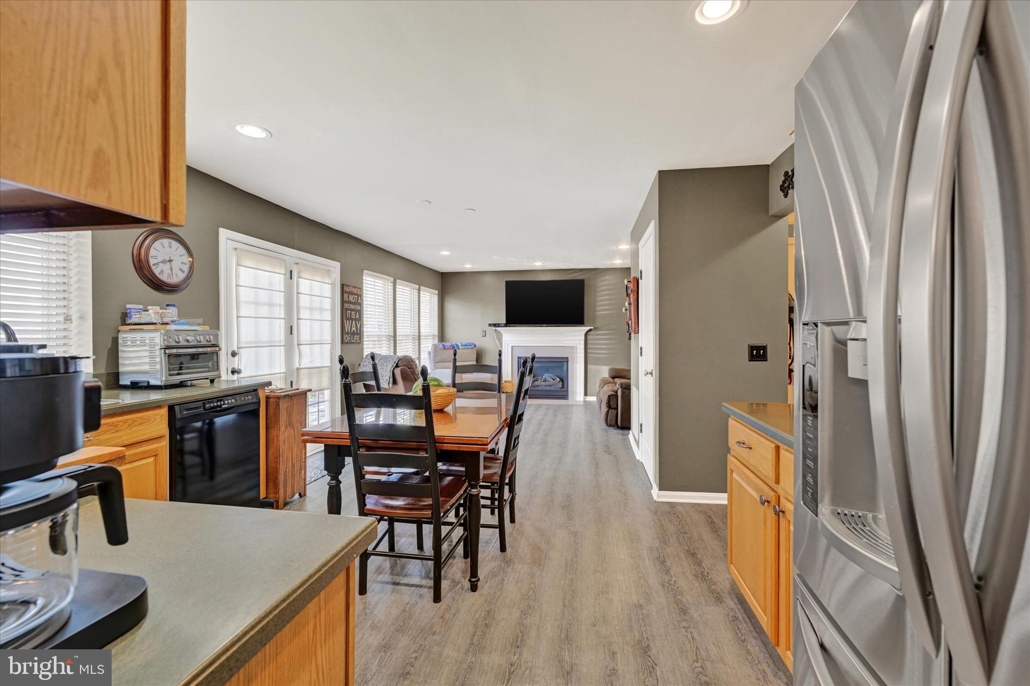4642 Bucks School House Road Rosedale, MD 21237 - Photo 14 of 33 a kitchen with stainless steel appliances granite countertop a refrigerator a stove a sink a dining table and chairs with wooden floor