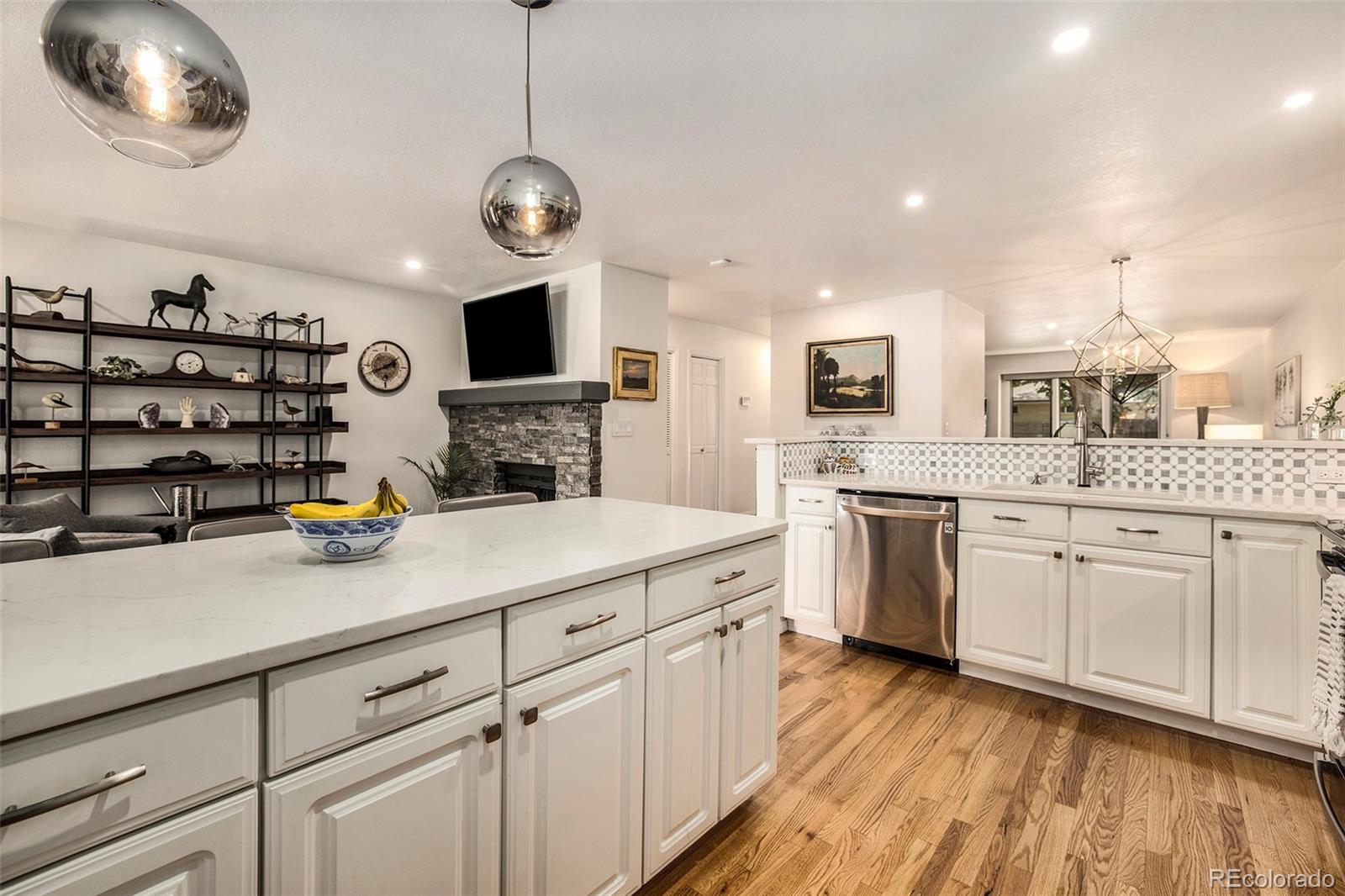 2365 Perry Street Denver, CO 80212 - Photo 8 of 24 a kitchen with stainless steel appliances white cabinets a sink a stove a dining table and chairs
