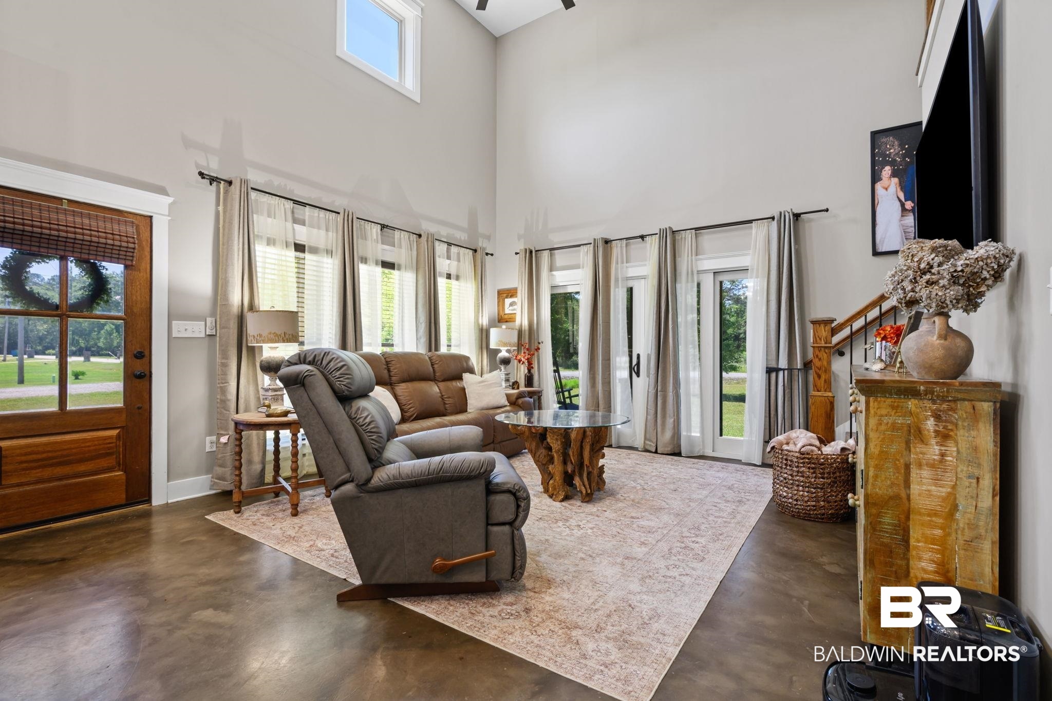 11025 Creax Road Axis, AL 36505 - Photo 10 of 45 Spacious living area featuring high ceilings, wood-finish flooring, and multiple glass-paned doors providing abundant natural light