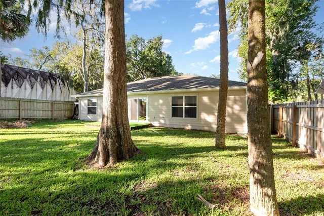 a view of a house with backyard and a tree