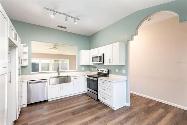 a kitchen with white cabinets and white appliances
