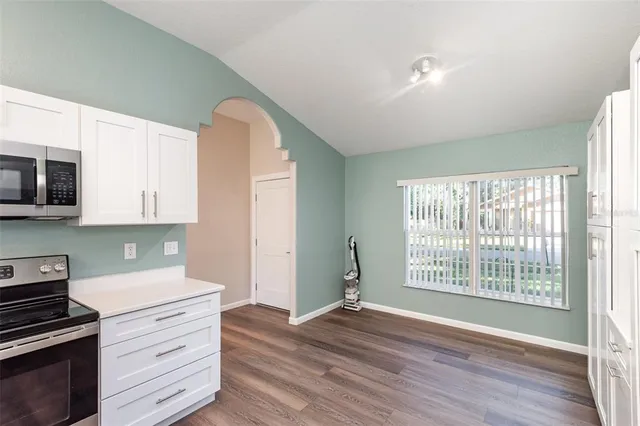 a view of a kitchen with wooden floor and electronic appliances