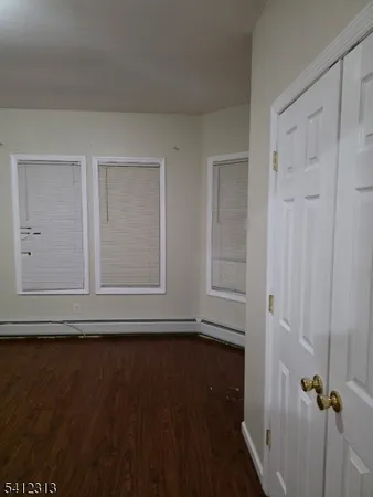 a view of room with hardwood floor and white walls