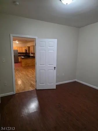 an empty room with wooden floor and cabinet