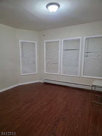 an empty room with wooden floor and window