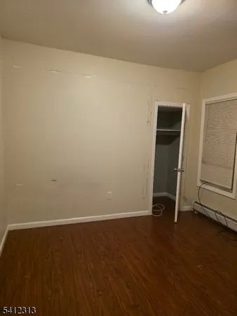 an empty room with wooden floor and mirror