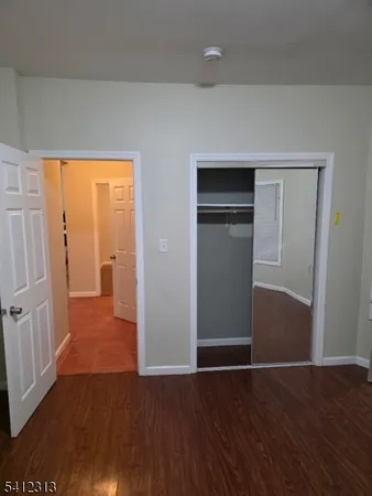 an empty room with wooden floor and closet