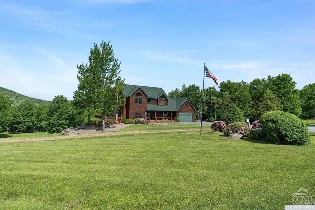 a front view of a house with a yard and trees
