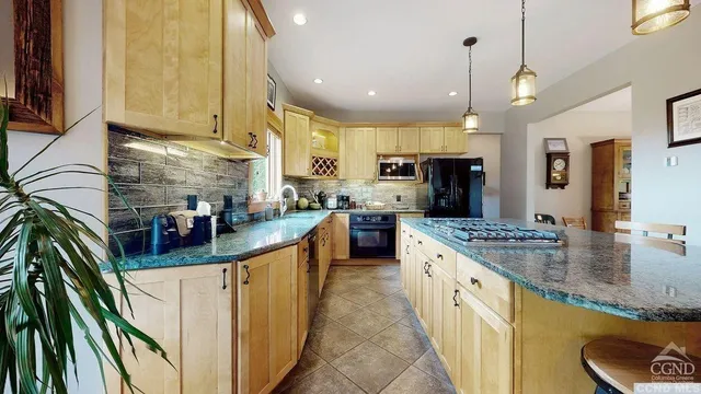 a kitchen with stainless steel appliances granite countertop a sink a oven and a refrigerator