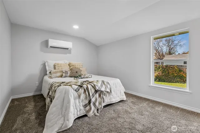 a bed sitting in a bedroom next to a window