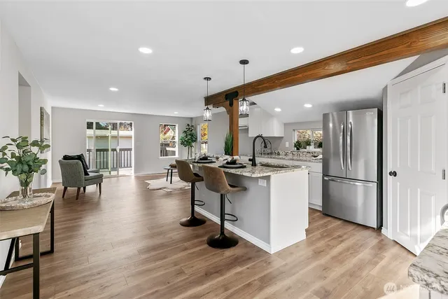 a kitchen with a sink appliances and dining table