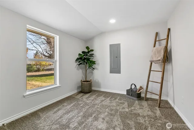 a view of an empty room with a window and a chandelier