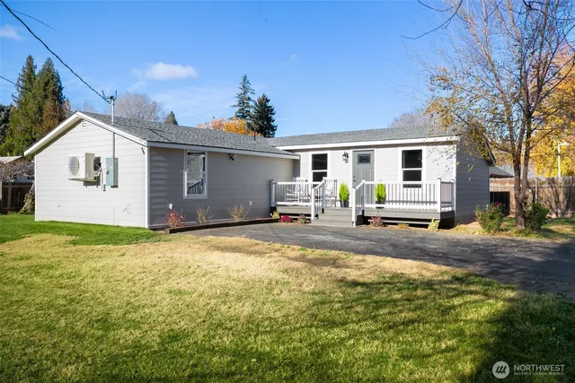 a view of a house with backyard and a tree