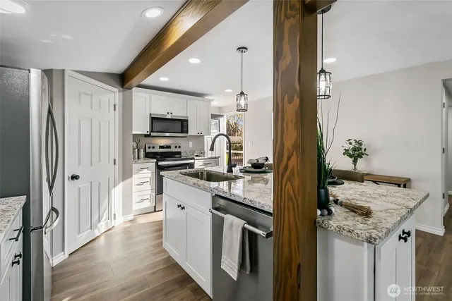 a kitchen with stainless steel appliances granite countertop a sink a stove and a refrigerator