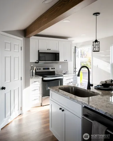 a kitchen with granite countertop a stove and a sink