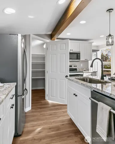 a kitchen with stainless steel appliances a refrigerator sink and microwave
