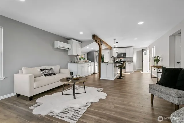 a living room with furniture and view of kitchen