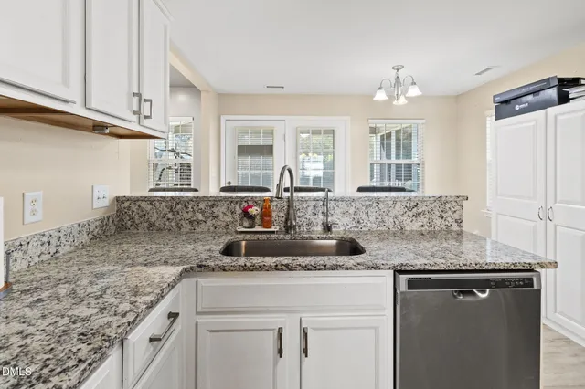 a kitchen with granite countertop a sink cabinets and window