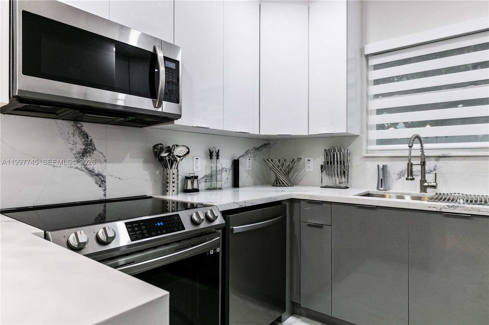 2376 Northwest 2nd Street Miami, FL 33125 - Photo 23 of 77 a kitchen with a sink and cabinets