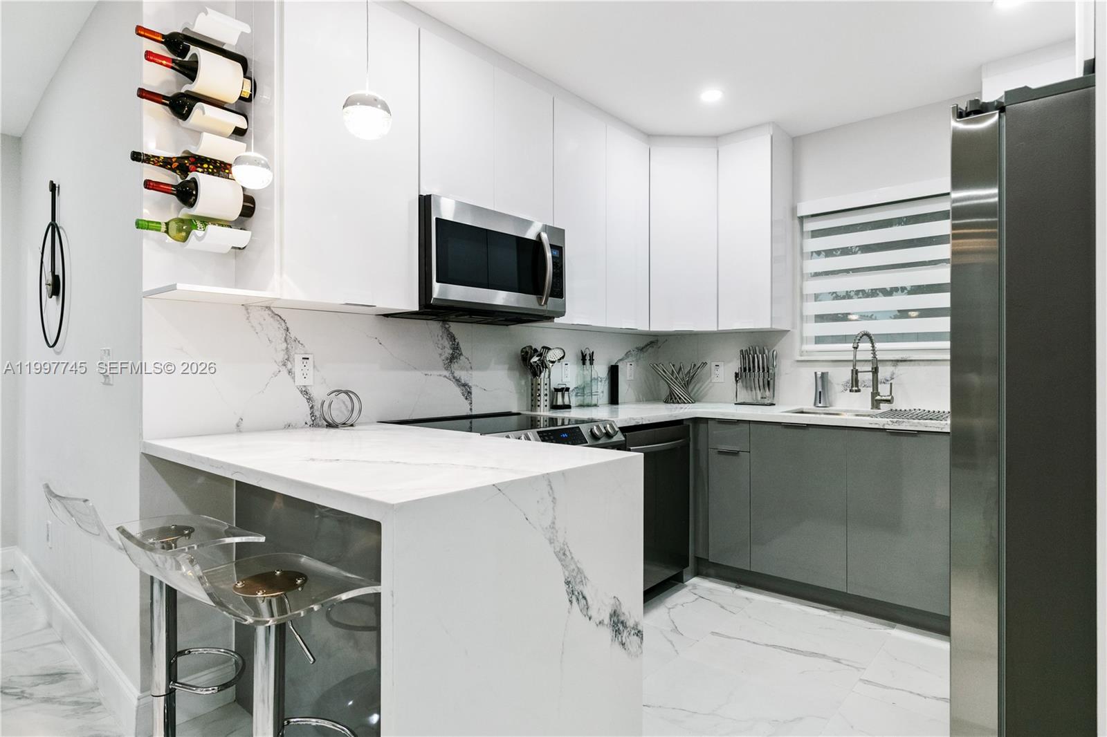 2376 Northwest 2nd Street Miami, FL 33125 - Photo 24 of 77 a kitchen with stainless steel appliances a stove a sink and a microwave